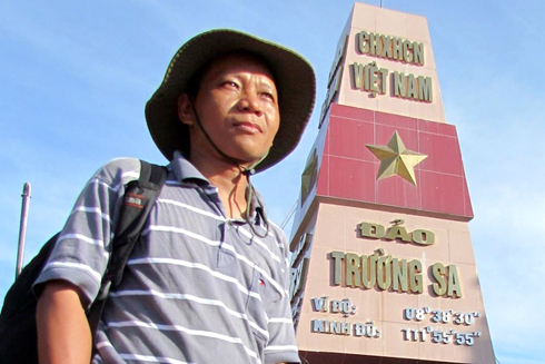 Nhà báo Nguyễn Đình Quân bên cột móc chủ quyền đảo Trường Sa.