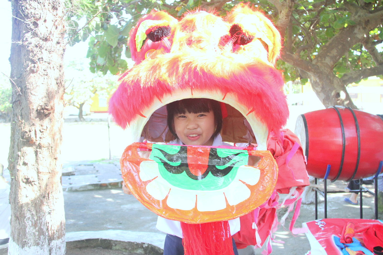 Một em nhỏ làm trò với đầu lân