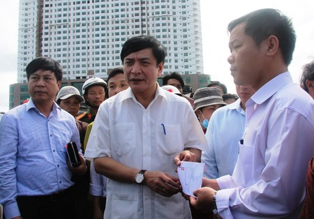 Ông Bùi Văn Cường (thứ 2 từ trái qua) trao số tiền hỗ trợ cho lãnh đạo UBND phường Vĩnh Phước để trao lại cho người dân.