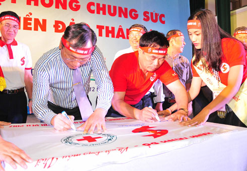 Các đại biểu ký lưu bút trên cờ xuyên Việt của Hành trình đỏ.