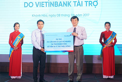 Ông Nguyễn Văn Thắng (bên trái) trao biểu trưng số tiền tài trợ xây dựng 214 căn nhà. 