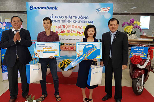 Ông Lâm Văn Kiệt - Giám đốc Sacombank khu vực Nam Trung bộ và Tây Nguyên và ông Phạm Tấn Minh - Giám đốc Sacombank Khánh Hòa trao 2 giải nhất cho khách hàng. 