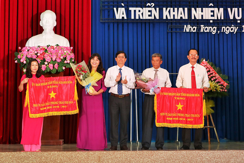 Ông Nguyễn Tấn Tuân trao cờ thi đua xuất sắc của UBND tỉnh cho Trường THPT Ngô Gia Tự và THPT Lý Tự Trọng.