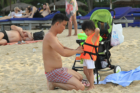 Ông bố người Việt chuẩn bị cho con xuống tắm biển