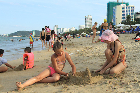 Hai em nhỏ người Nga xây lâu đài cát trên biển Nha Trang
