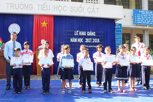 Đại diện Báo Khánh Hoà và lãnh đạo Côn ty Long Sinh trao học bổng cho các em học sinh.