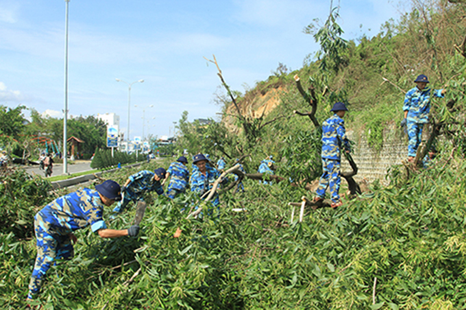 Học viên Học viện Hải quân tham gia chặt dọn cây xanh bị ngã đổ trên đường Phạm Văn Đồng (TP. Nha Trang).