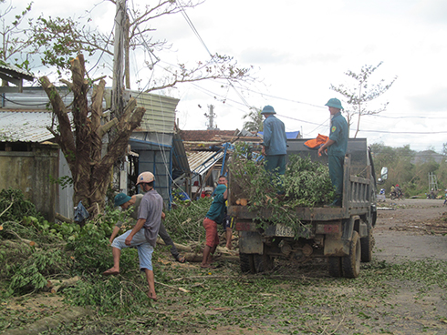 Dân quân xã Khánh Bình giúp dân dọn dẹp cây cối.