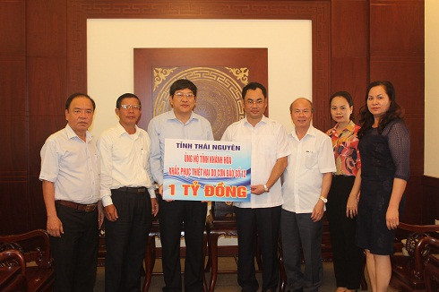 Ông Trịnh Việt Hùng (thứ 4 từ phải qua) trao số tiền 1 tỷ đồng cho nhân dân Khánh Hòa khắc phục hậu quả do bão.