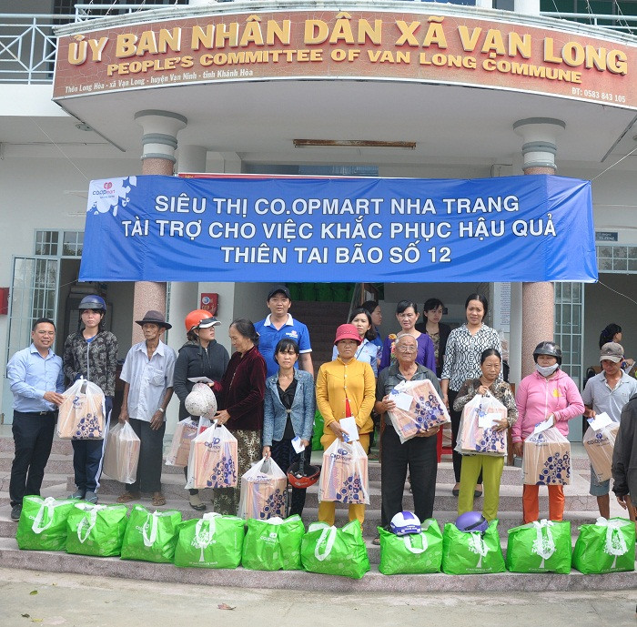 Đại diện Siêu thị Co.opmart Nha Trang tặng quà cho người dân xã Vạn Long (huyện Vạn Ninh).