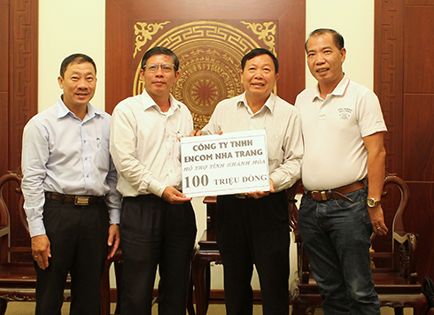 Đồng chí Trần Ngọc Thanh (bên trái) tiếp nhận số tiền ủng hộ của Công ty TNHH ENCOM Nha Trang.