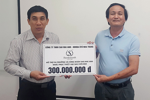 Ông Lương Phúc Ánh - Chủ tịch hội đồng quản trị Công ty Sao Mai Anh trao 300 triệu đồng cho ông Phạm Đức Tiến - Giám đốc điều hành Honda Ôtô Nha Trang để tổ chức thực hiện.