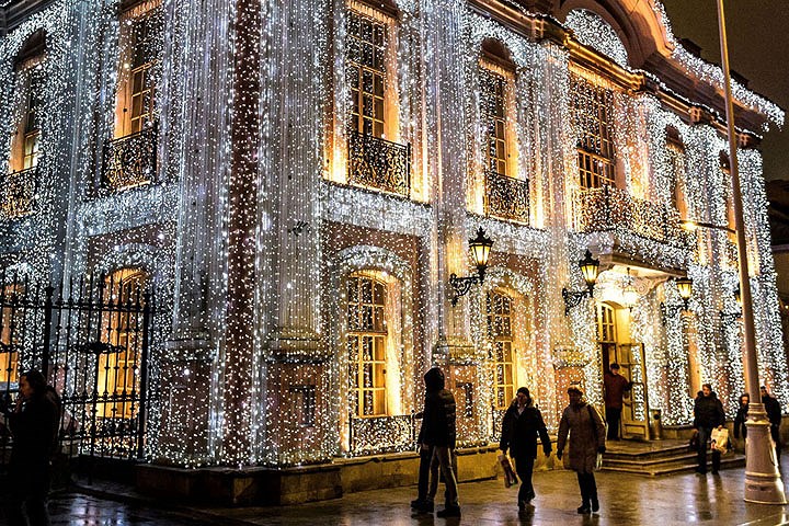 Khách bộ hành phía trước nhà hàng Café Pushkin nổi tiếng, được trang hoàng đèn màu cho kỳ nghỉ lễ sắp tới ở Moscow, Nga.