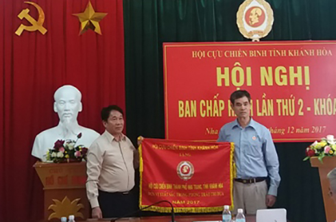 Ông Trần Văn Hạnh - Chủ tịch Hội CCB tỉnh Khánh Hoà (bên trái) trao “Cờ thi đua xuất sắc” cho Hội CCB TP. Nha Trang.