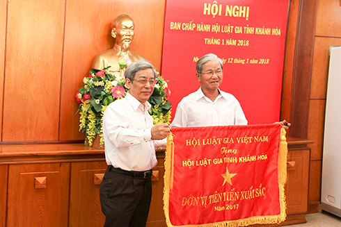 Ông Lê Xuân Thân trao cờ thi đua cho đại diện Hội Luật gia tỉnh.
