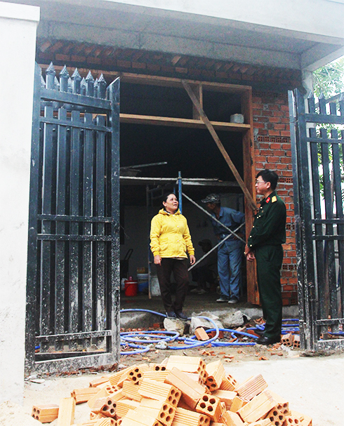 Thiếu tá Phùng Ngọc Khánh kiểm tra việc xây nhà  cho gia đình bà Nguyễn Thị Trường Nguyên.