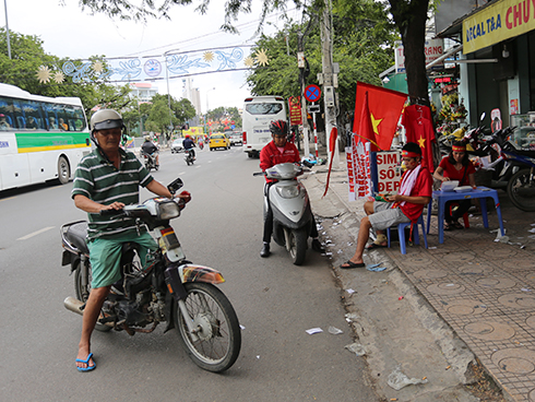 Nhiều người dân tìm mùa cờ, hình dán trên đường Thái Nguyên.