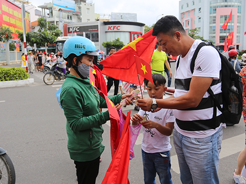 Một khách hàng tìm mua cờ, băng rôn cổ vũ U23 Việt Nam.