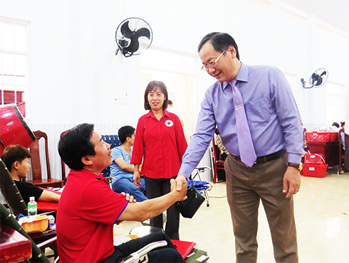 Ông Nguyễn Đắc Tài động viên người tham gia hiến máu tình nguyện.