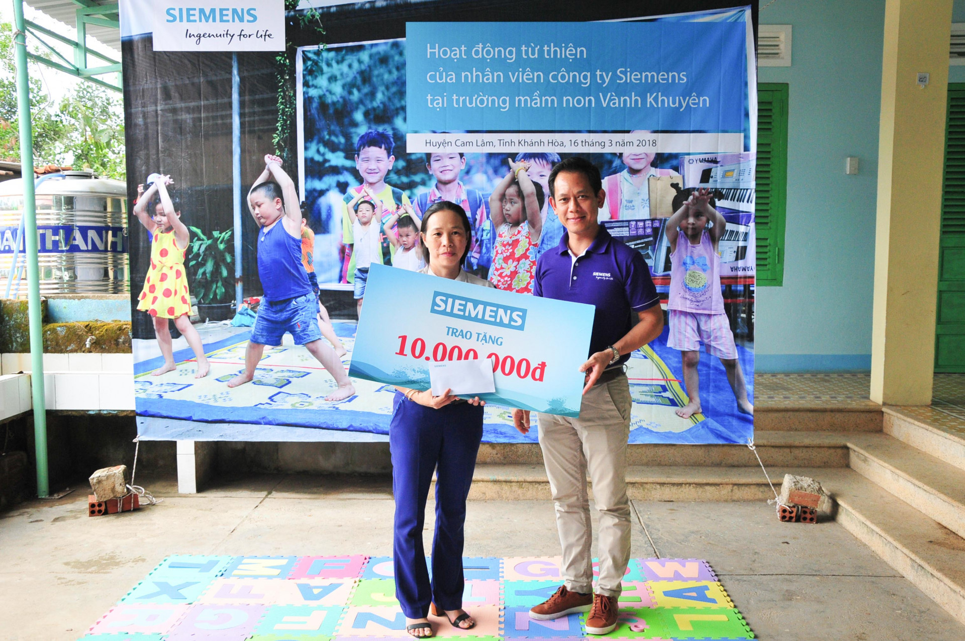 Đại diện Công ty TNHH Siemens trao tiền hỗ trợ cho Trường Mầm non Vành Khuyên, điểm trường Suối Lau