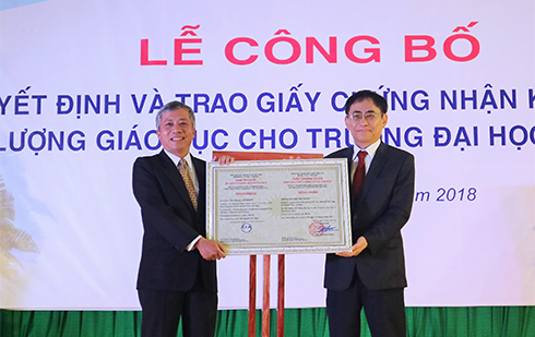 PGS.TS Nguyễn Hội Nghĩa - Phó Giám đốc Đại học Quốc gia  TP. Hồ Chí Minh, Giám đốc Trung tâm Kiểm định chất lượng giáo dục (bên phải) trao giấy chứng nhận cho nhà trường.