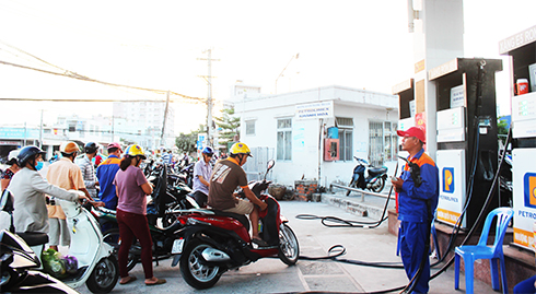 Tại một cửa hàng xăng dầu ở Nha Trang, người dân đứng chờ đổ xăng RON 95 trong khi cột bơm xăng E5 vẫn vắng khách.
