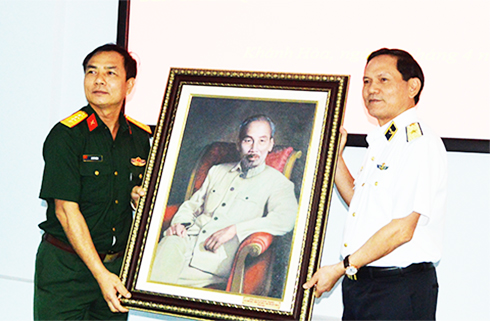 Đại diện đoàn công tác (bên trái) tặng ảnh Bác Hồ cho Học viện Hải quân.