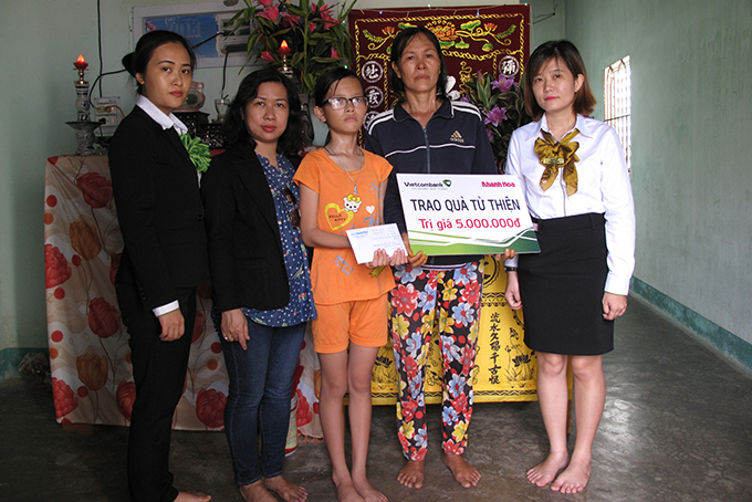 Đại diện Báo Khánh Hòa và Vietcombank Nha Trang trao tiền ủng hộ cho hai mẹ con bà Lửng