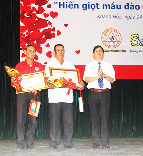 Đồng chí Nguyễn Tấn Tuân trao bằng khen của Thủ tướng Chính phủ cho đại diện 2 gia đình.