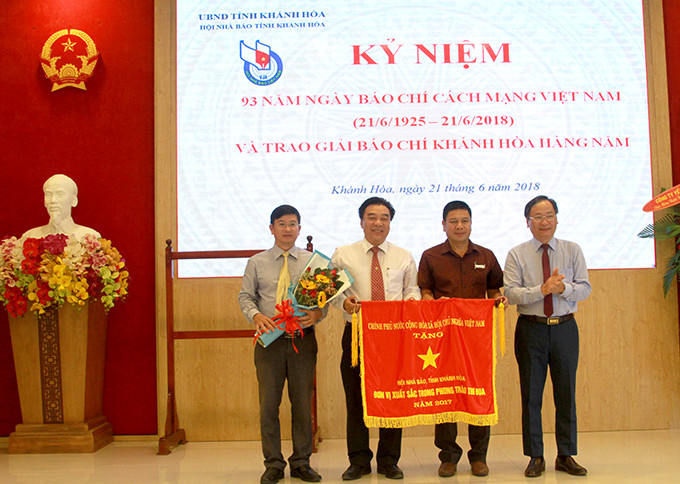 Ông Nguyễn Đắc Tài trao cờ thi đua của Chính phủ cho Hội Nhà báo tỉnh Khánh Hòa.