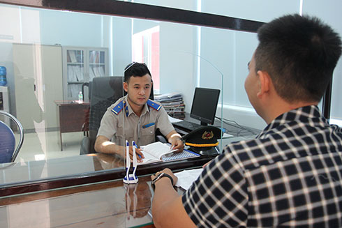 Công chức bộ phận Một cửa Cục Thi hành án dân sự tỉnh Khánh Hòa tiếp đương sự trong trang phục ngành mới.