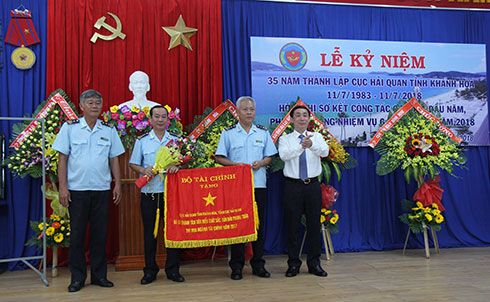 Ông Hoàng Việt Cường trao cờ của Bộ Tài chính cho đại diện Cục Hải quan tỉnh Khánh Hòa.