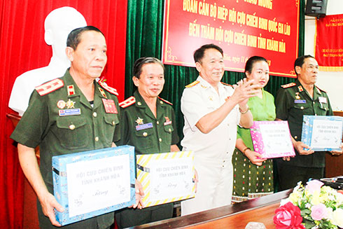Ông Trần Văn Hạnh (đứng giữa) tặng quà lưu niệm cho đoàn Hiệp hội Cựu chiến binh quốc gia Lào.