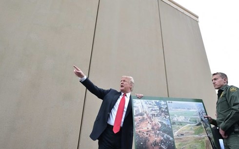 Tổng thống Donald Trump đứng bên bức tường mẫu sẽ được dựng lên dọc biên giới Mỹ-Mexico. Ảnh: AFP/Getty