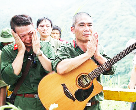 Nhạc sỹ Trương Quý Hải (bên phải) tưởng nhớ đồng đội  ở nghĩa trang Vị Xuyên- Hà Giang