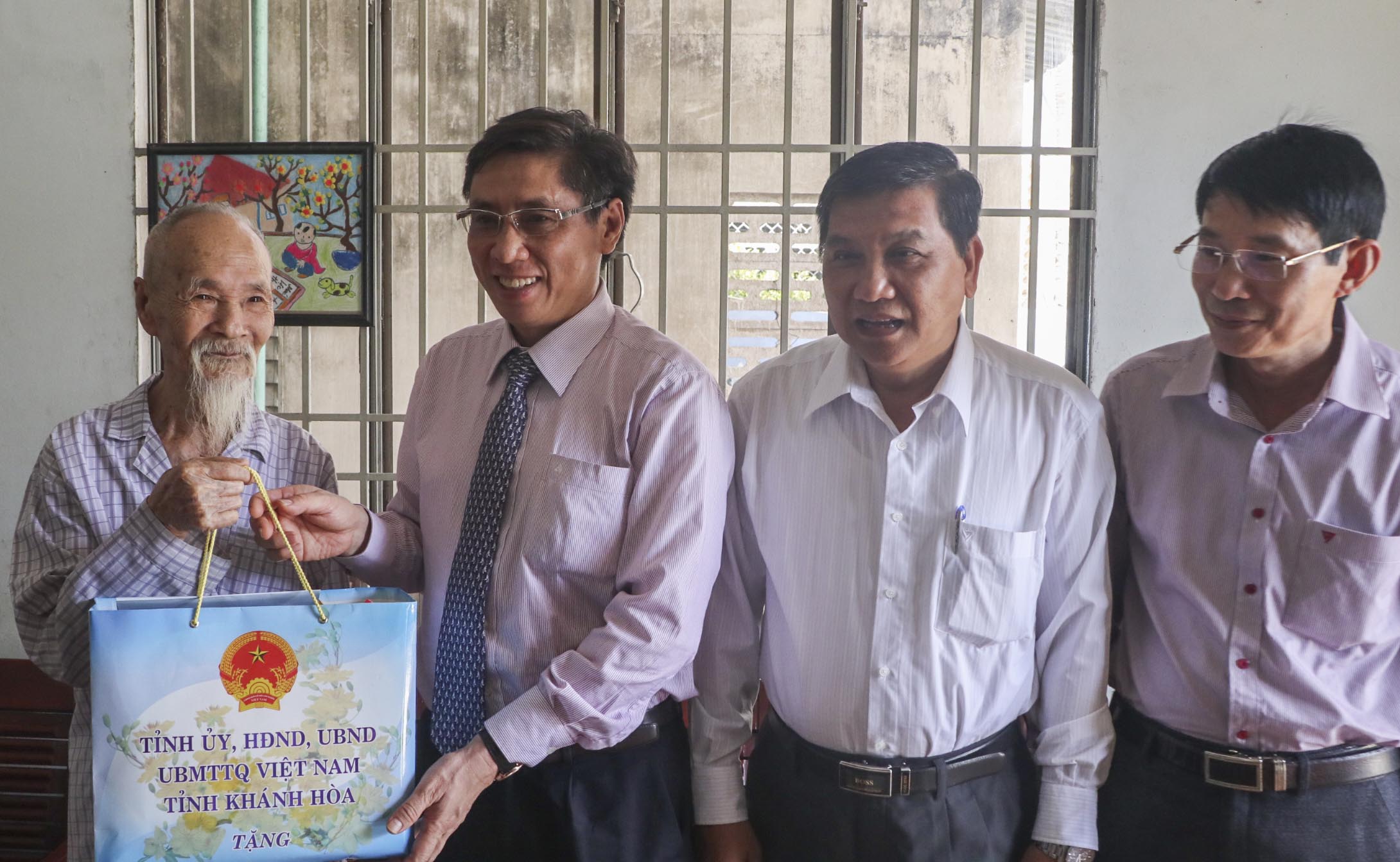 Ông Lê Đức Vinh trao quà cho ông Ngô Tam - Thương binh (Diên An).