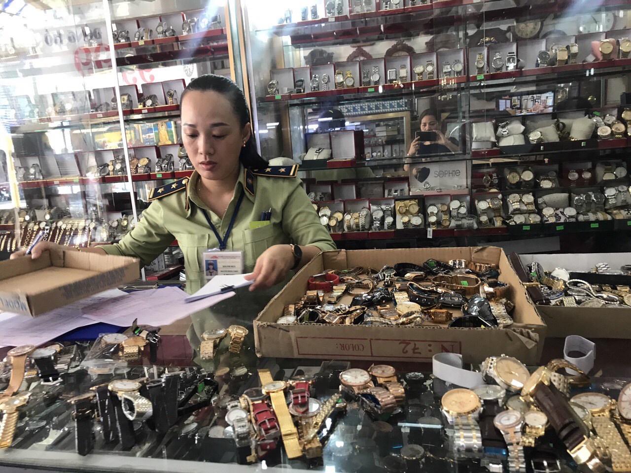 Cán bộ quản lý thị trường kiểm đếm số lượng đồng hồ có dấu hiệu làm nhái các thương hiệu nổi tiếng.