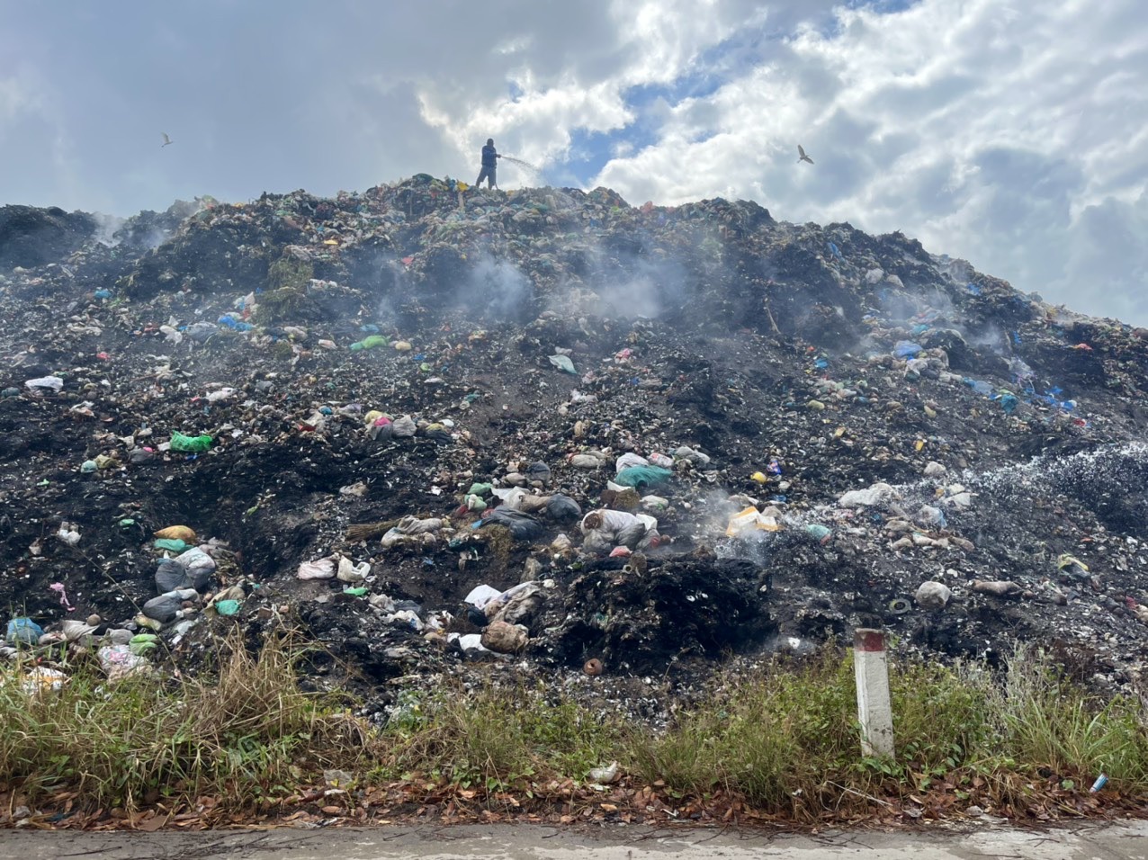 Tưới nước để hạn chế khói bụi ở bãi rác Hòn Ngang