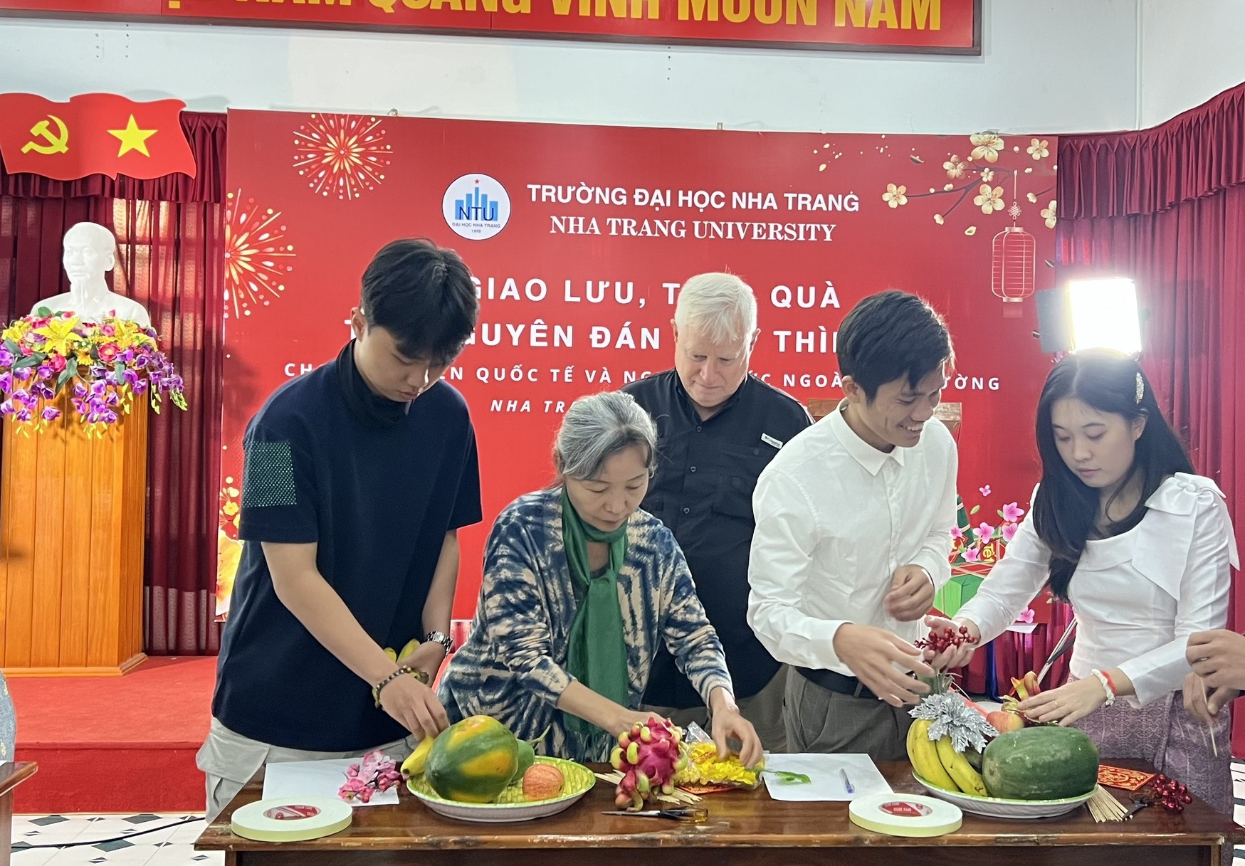 Các sinh viên, người nước ngoài tham gia trang trí mâm ngũ quả. 