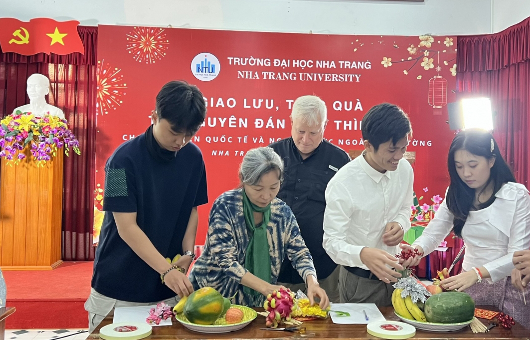 Foreigners and students with traditional five-fruit tray decoration.