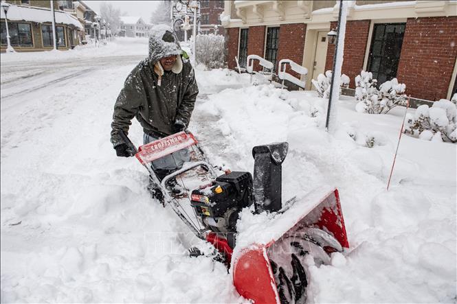 Người dân dọn tuyết trên đường phố tại Methuen, Massachusetts, Mỹ, ngày 7/1/2024. Ảnh: AFP/TTXVN

