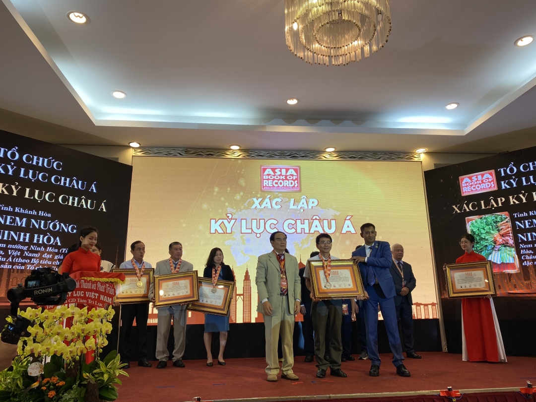 The representative of Ninh Hoa Town receiveing record certificate for Ninh Hoa grilled pork rolls