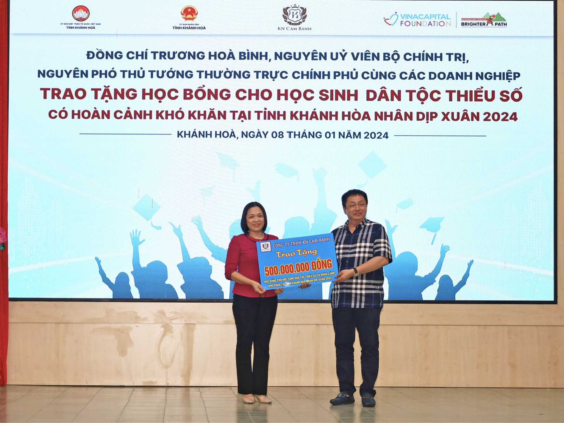 Đại diện Công ty TNHH KN Cam Ranh (bên phải) trao bảng tượng trưng kinh phí hỗ trợ học bổng cho tỉnh Khánh Hòa.