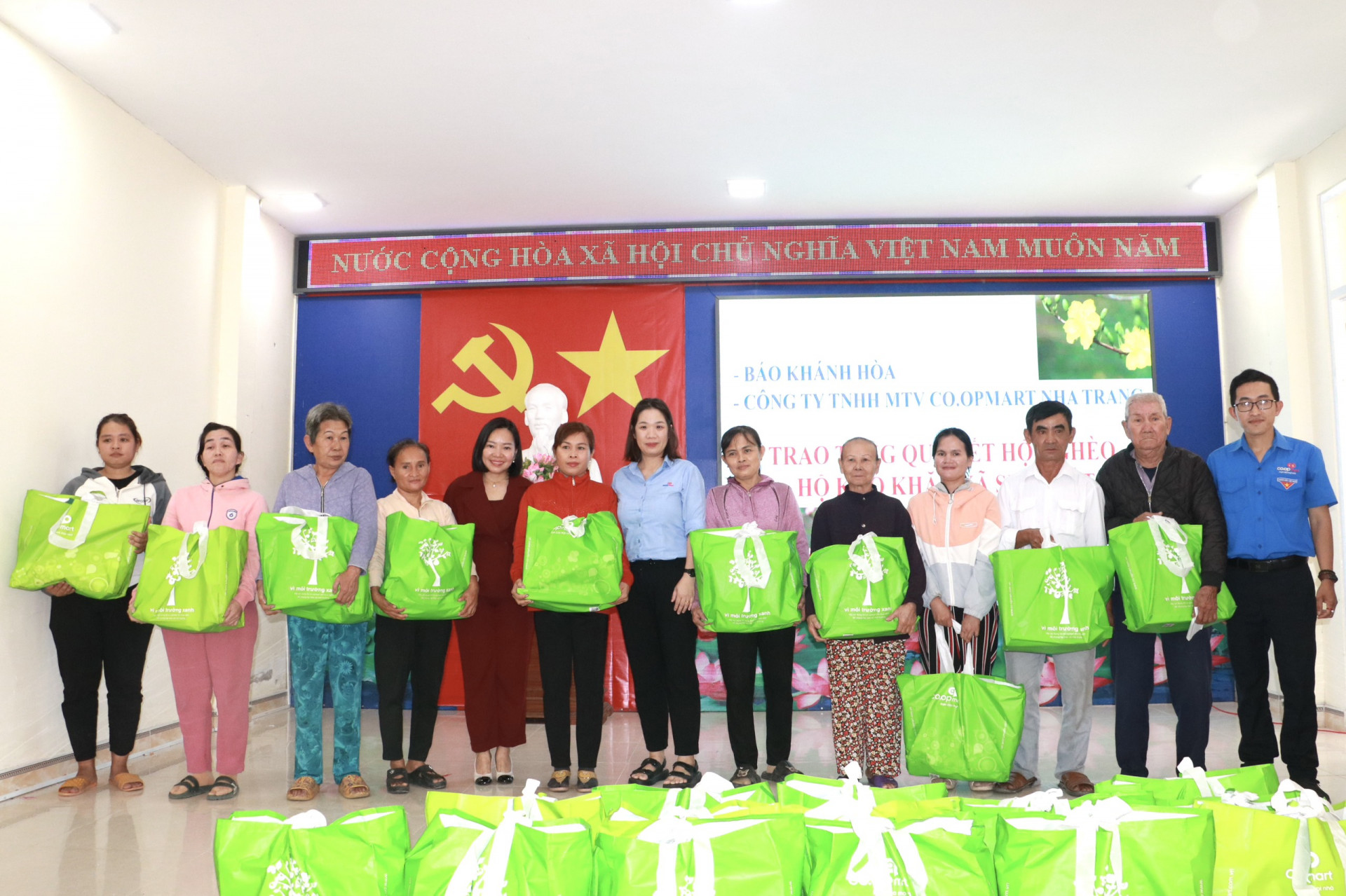 Bà Thái Thị Lệ Hằng - Tổng Biên tập Báo Khánh Hòa (thứ 5 từ trái qua) và đại diện Siêu thị Co.opmart Nha Trang trao quà cho người dân