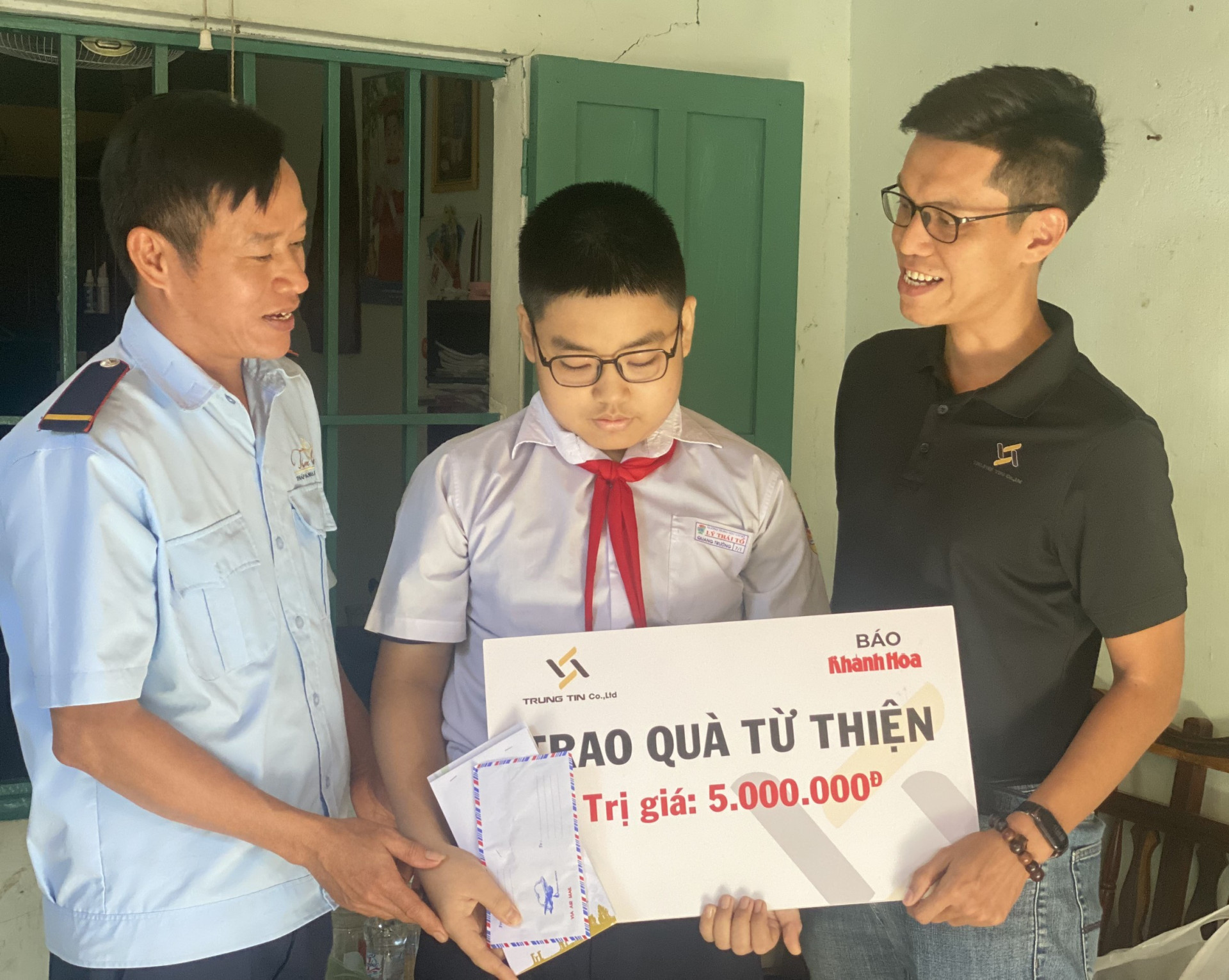 Ông Đỗ Nguyễn - Phó Giám đốc Công ty TNHH Tư vấn và Đầu tư Trung Tín trao tiền ủng hộ cho em Hồ Quang Trường