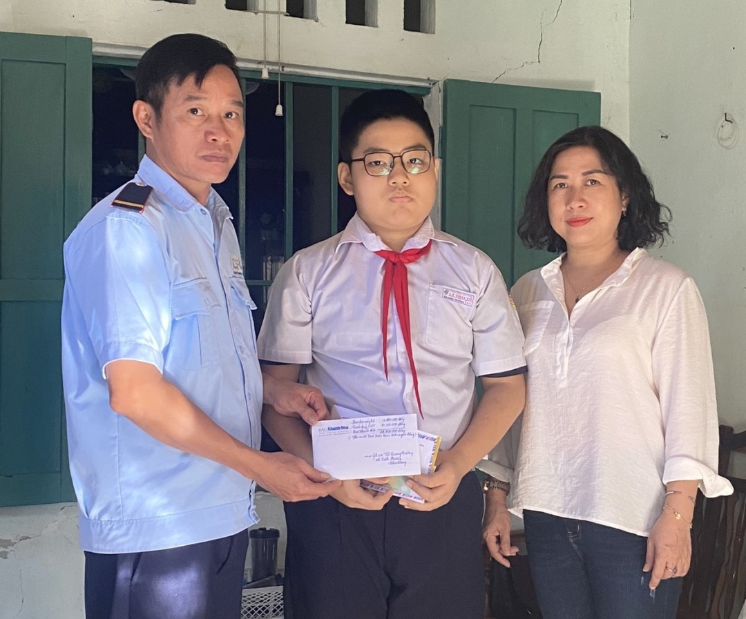 Đại diện Báo Khánh Hòa trao tiền ủng hộ của bạn đọc cho em Hồ Quang Trường