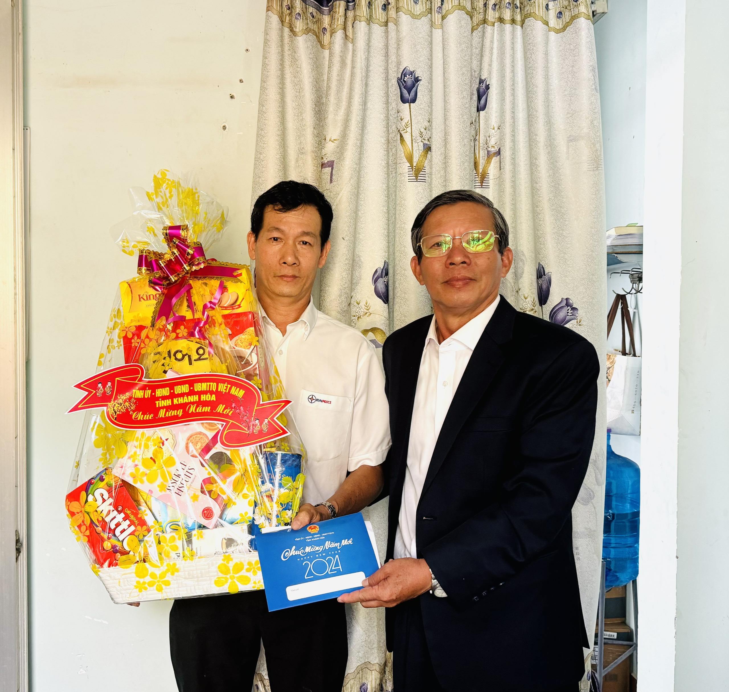 Đồng chí Trần Ngọc Thanh (bìa phải) tặng quà cho đại diện gia đình đồng chí Đặng Nhiên