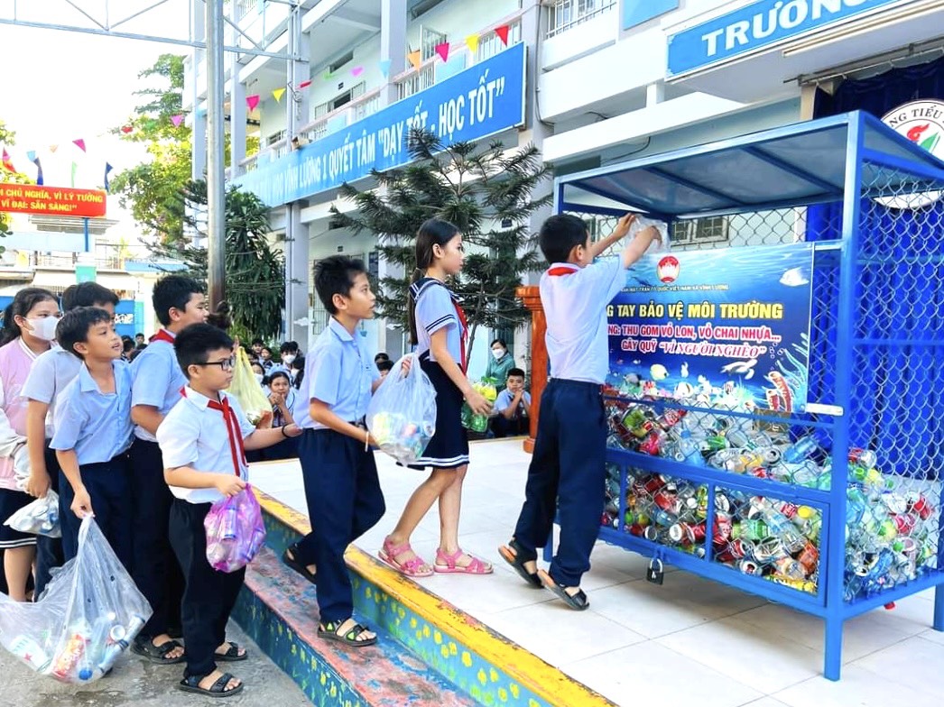 Học sinh Trường Tiểu học Vĩnh Lương 1 thu gom vỏ lon, chai nhựa bỏ vào điểm tập kết tại trường