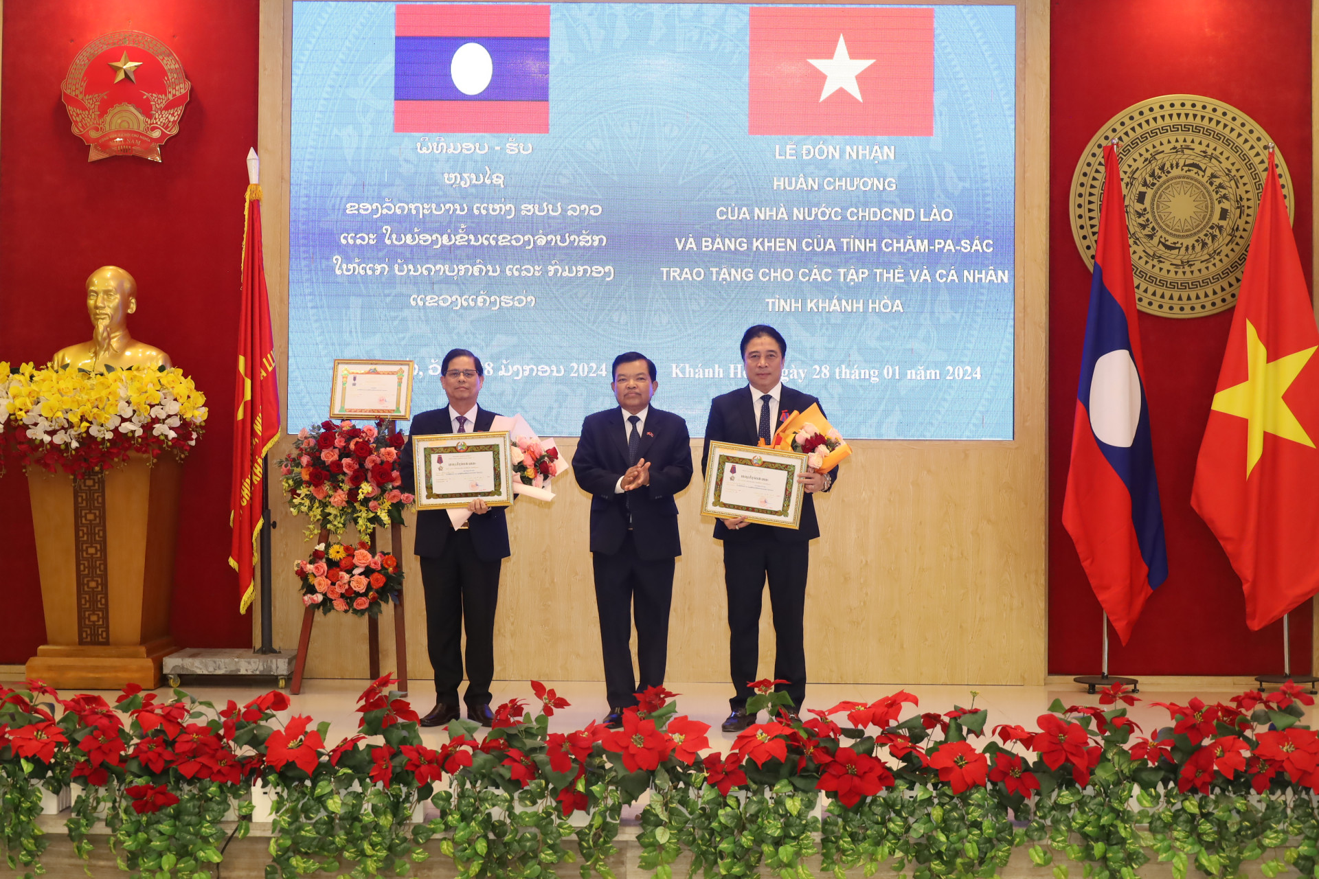 Đồng chí Nguyễn Khắc Toàn và đồng chí Nguyễn Tấn Tuân đón nhận Huân chương Itxala hạng III do Chủ tịch nước CHDCND Lào tặng.