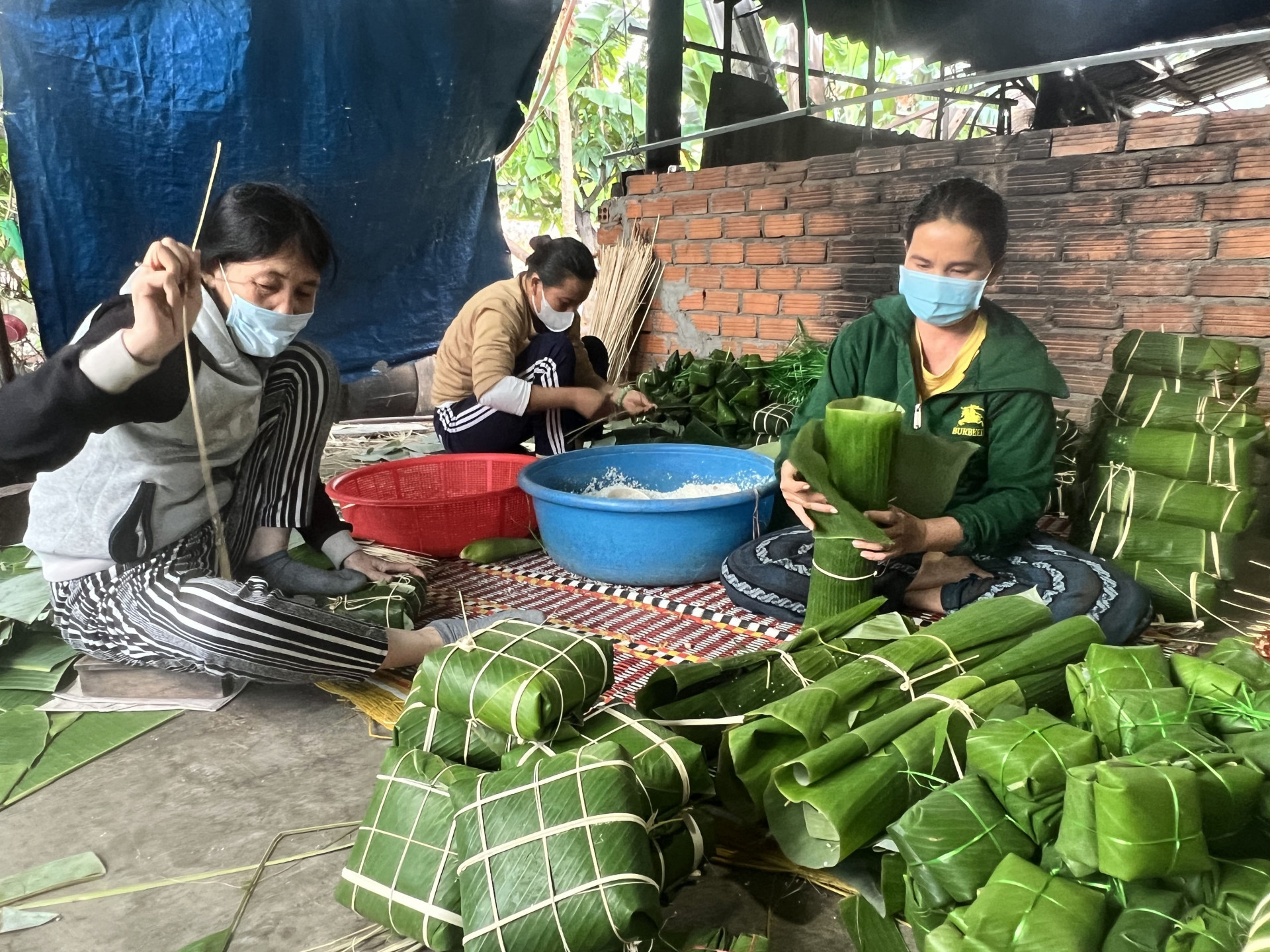 Vợ chồng bà Hồ Thị Đắc Lợt phải tăng nhân công, chia ca làm để kịp cung cấp bánh chưng, bánh tét cho thị trường Tết.